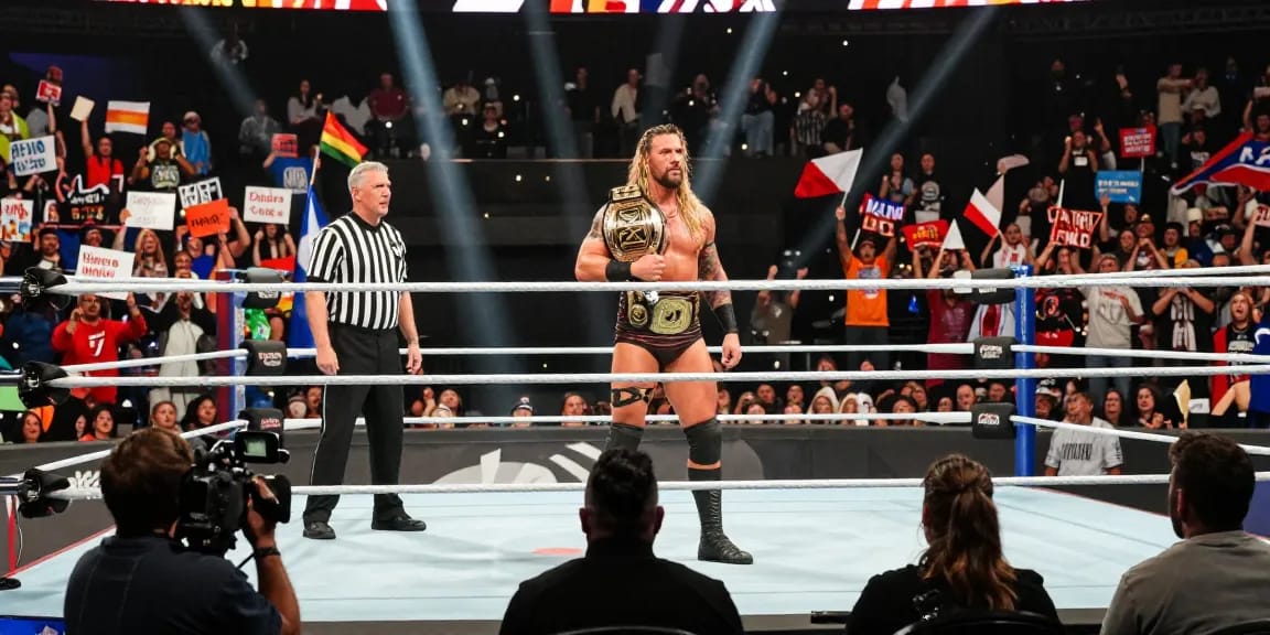 Roman Reigns in the ring during his historic title reign, surrounded by cheering fans and bright arena lights.