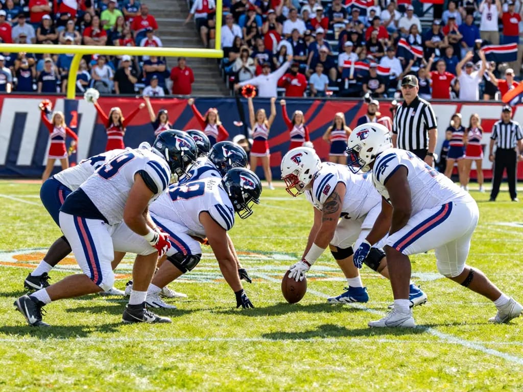 Team players in custom american football uniform usa strategizing during a game day on a bright field